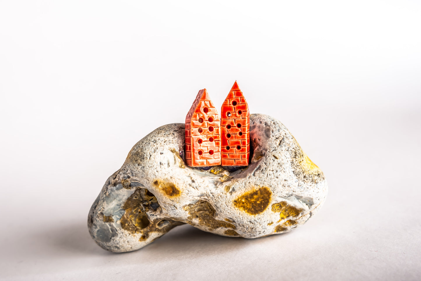 Hand-built red ceramic houses on a rock