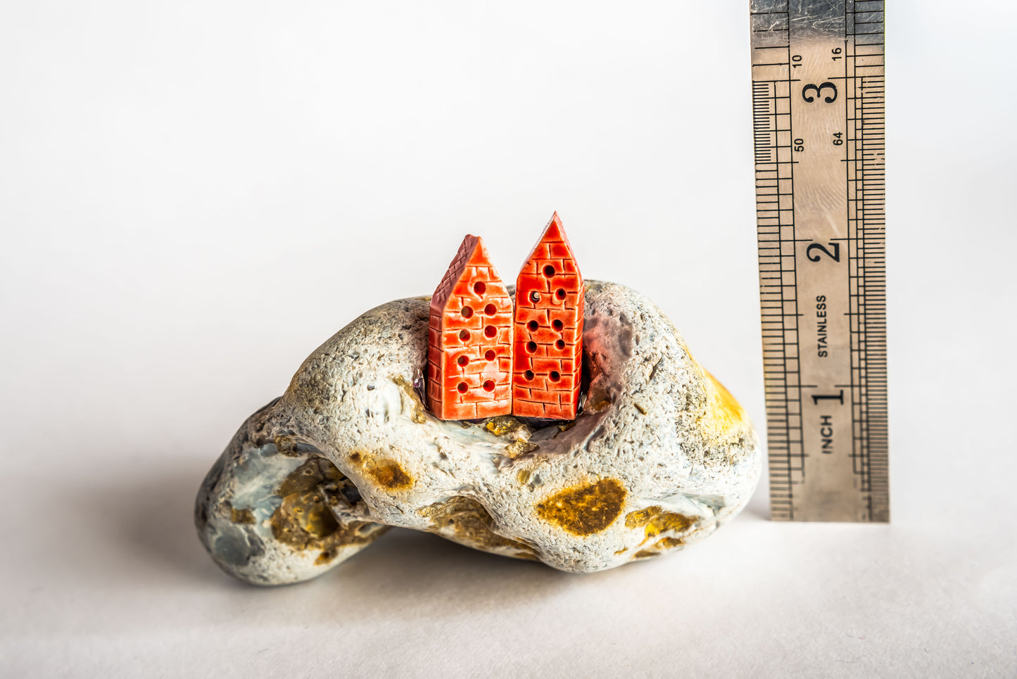 Hand-built red ceramic houses on a rock