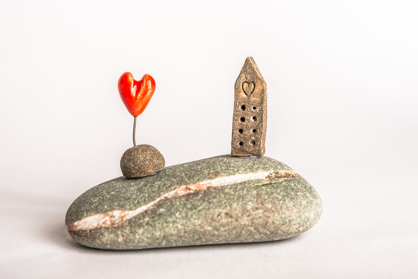 Hand-built brown ceramic house on a rock