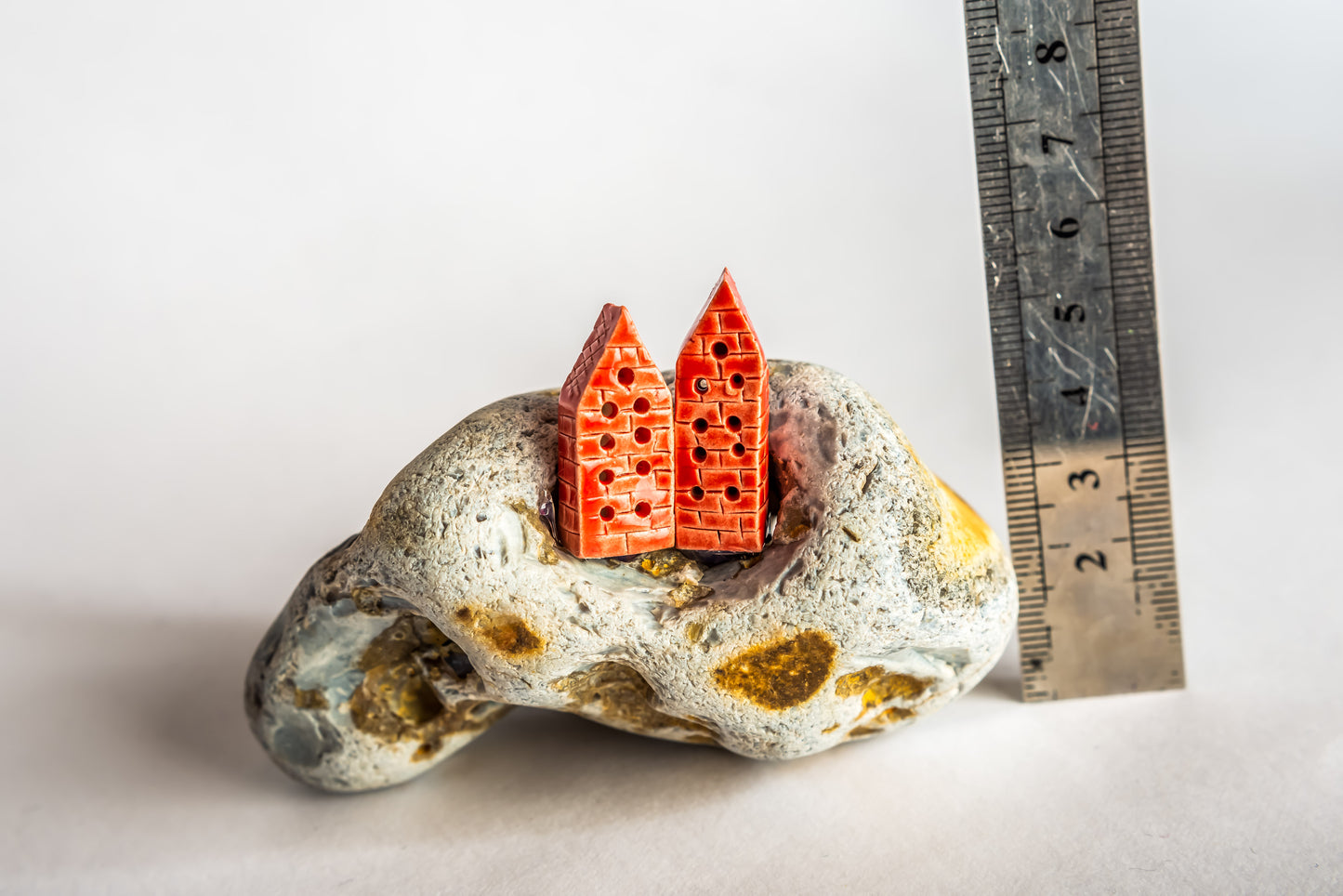 Hand-built red ceramic houses on a rock
